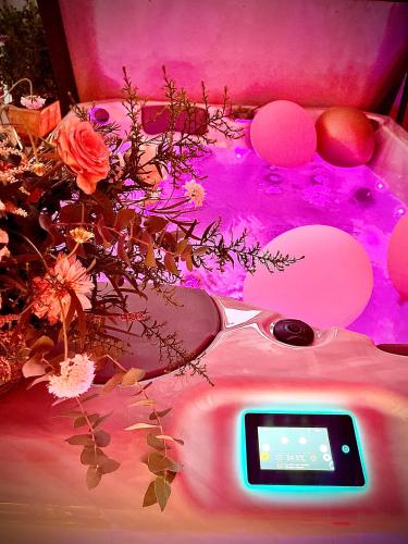 a digital clock sitting on top of a table with flowers at Suite San Rocco Wellness&Spa in Ruvo di Puglia
