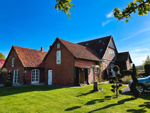 une grande maison en briques avec une cour d'herbe dans l'établissement Pauernhof Ferienwohnungen, à Bad Nenndorf