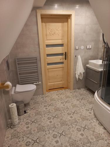 baño con aseo, lavabo y puerta en Domki Widokowe Panorama Tatr en Biały Dunajec