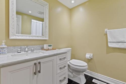 uma casa de banho com um WC, um lavatório e um espelho. em Luxurious Sierra Lane Escape em Blue Mountains