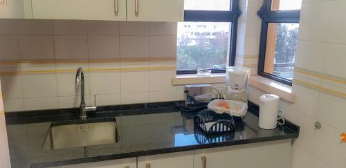 a kitchen with a sink and a counter top at Apartamento T2 Club Amarílis - Portimão in Portimão