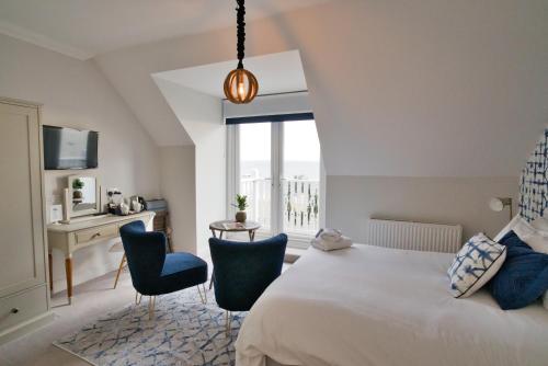 a bedroom with a bed and two chairs and a desk at Beaches Guest House in Southend-on-Sea