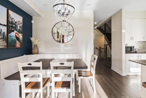 a dining room with a black table and white chairs at Modern home with a pool sauna pooltable & mountain view in Collingwood