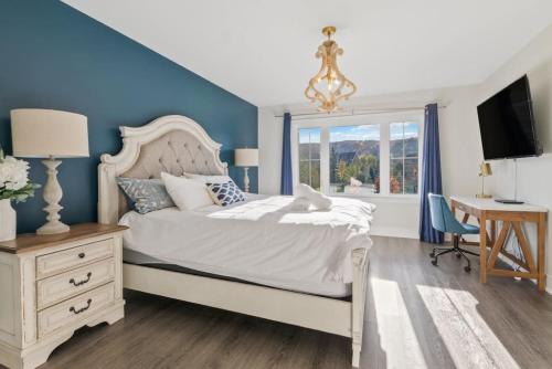 a bedroom with a bed and a desk and a window at Modern home with a pool sauna pooltable & mountain view in Collingwood