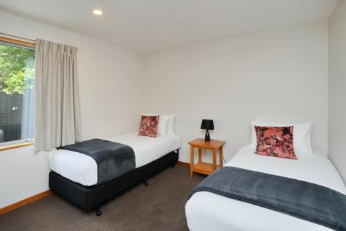 two beds in a room with a window at 306 Motel Apartments in Christchurch