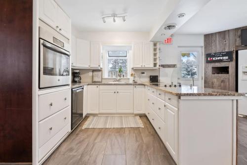 a kitchen with white cabinets and a counter top at Paradise Manor w Hot tub Sauna & Putting Green in Blue Mountains