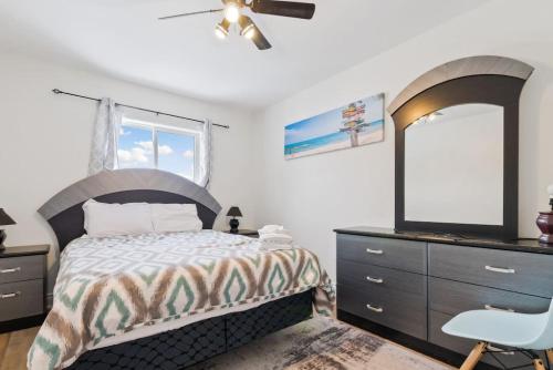 a bedroom with a bed with a dresser and a mirror at Paradise Manor w Hot tub Sauna & Putting Green in Blue Mountains