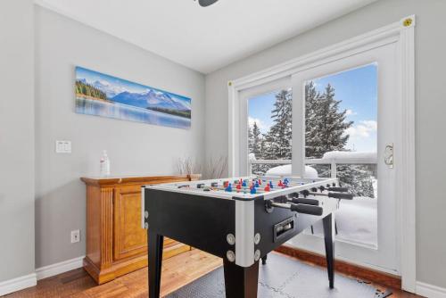 a room with a foosball table in front of a window at Paradise Manor w Hot tub Sauna & Putting Green in Blue Mountains