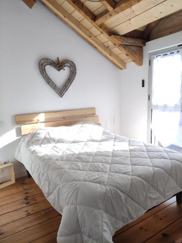 Obalie-Le Vignemale في كوتيريه: غرفة نوم مع سرير مع علامة على القلب على الحائط