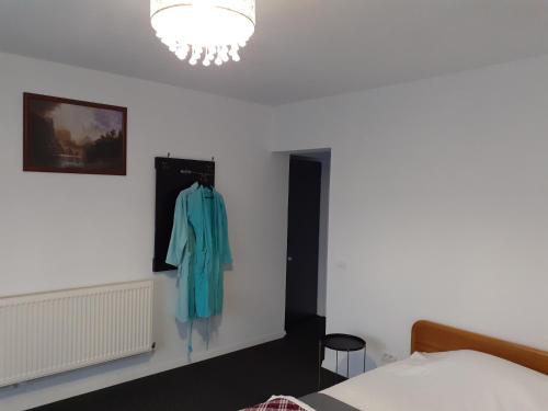 a bedroom with a blue shirt hanging on a wall at Salcia in Tăşnad