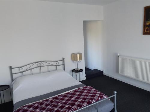 a bedroom with a bed with a plaid blanket at Salcia in Tăşnad