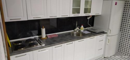 a kitchen with white cabinets and a sink at Apartman House Jasmina in Bihać