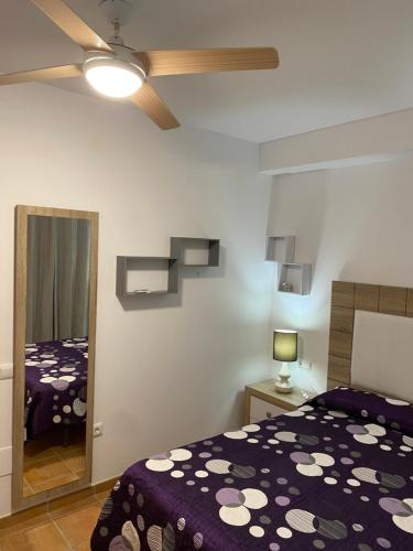 1 dormitorio con cama y espejo en Precioso apartamento en complejo residencial. en Alcaucín