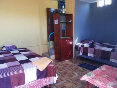 una habitación con 2 camas y un estante en ella en Hospedaje Arvakeni, en San Cristobal
