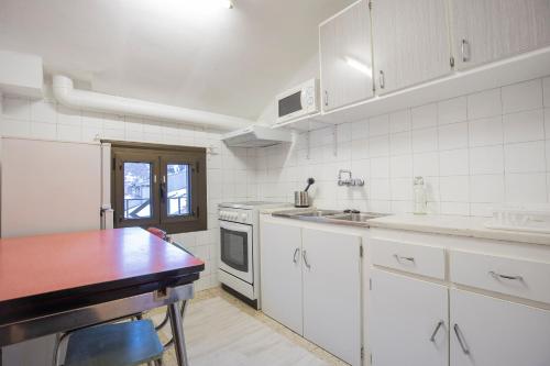 uma cozinha com electrodomésticos brancos e uma mesa de madeira em JAT MOUNTAIN HOUSES - Casa Agustí 4t pis - Cèntric, al costat del Telecabina de Canillo em Canillo
