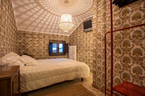 - une chambre avec un lit et un lustre dans l'établissement JAT MOUNTAIN HOUSES - Casa Agustí 4t pis - Cèntric, al costat del Telecabina de Canillo, à Canillo