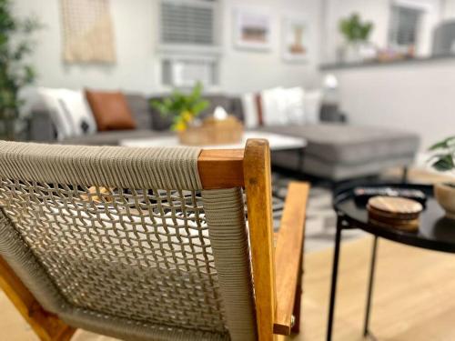 a rattan chair in a living room with a table at Steps To The Beach, Pacific City and Main Street - #5 in Huntington Beach