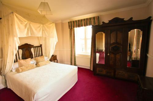 a bedroom with a bed and a dresser at Kilcooly's Country House Hotel in Ballybunion