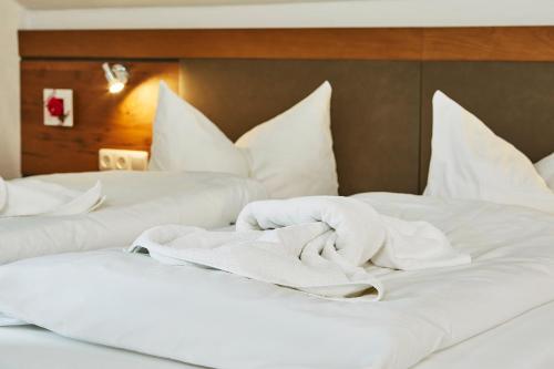 two white beds with white sheets and pillows at Ruperti - Gästehaus in Ainring