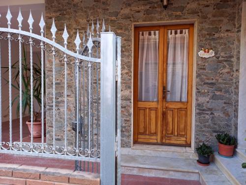 a wooden door on a house with a fence at Appartamento il tulipano in Assemini