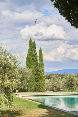a swimming pool in a garden with a fountain at Fattoria La Loggia in San Casciano in Val di Pesa