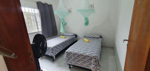 two twin beds in a room with a window at Casa Azul Gamboa in Gamboa