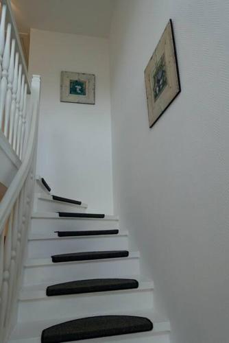 a stairway with a black and white stair case at Hus an de Marsch in Midlum
