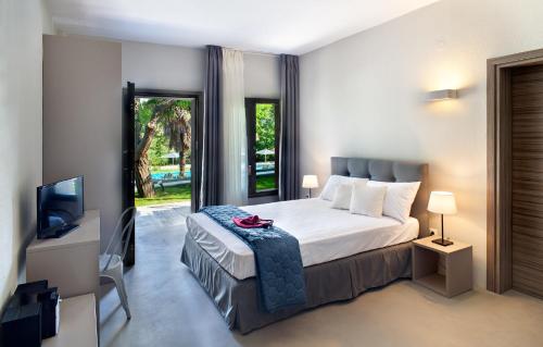 サニビーチにあるSani Woods Studios & Apartmentsのベッドとテレビが備わるホテルルームです。