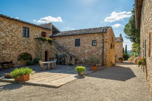 a stone building with a table in a courtyard at Fattoria La Loggia in San Casciano in Val di Pesa