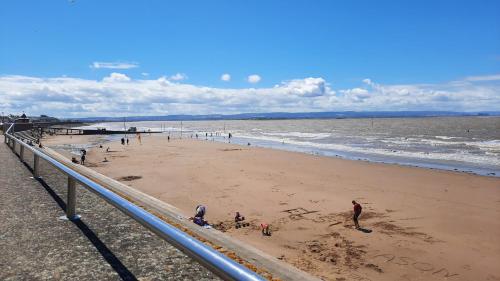 un grupo de personas en una playa cerca del océano en "Near to the Beach "- 2 bedroom Flat Sleeps up to 5, en Burnham-on-Sea