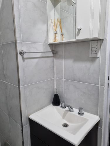 uma casa de banho com um lavatório branco e um espelho. em Departamento en el centro em Mercedes