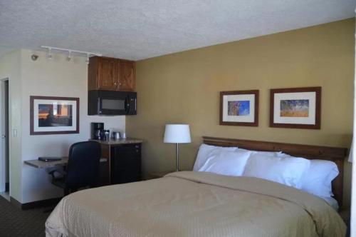 a hotel room with a bed and a desk and a computer at Battle Mountain Inn in Battle Mountain