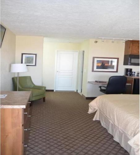 a hotel room with a bed and a desk and chair at Battle Mountain Inn in Battle Mountain