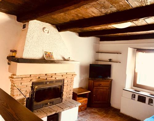 a living room with a fireplace and a television at Alloggio in vetta alla montagna in Montese