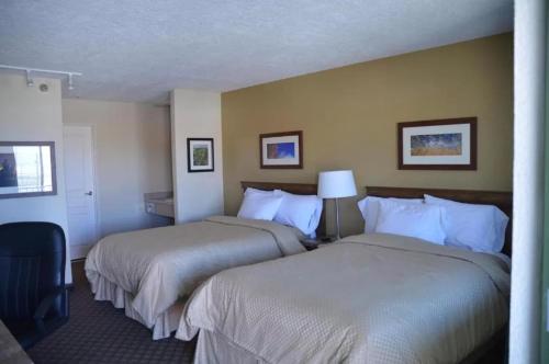 a hotel room with two beds and a lamp at Battle Mountain Inn in Battle Mountain