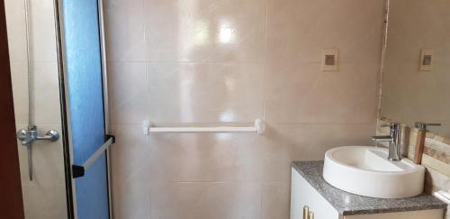 a small bathroom with a sink and a shower at La Quimera del Águila in Atlántida