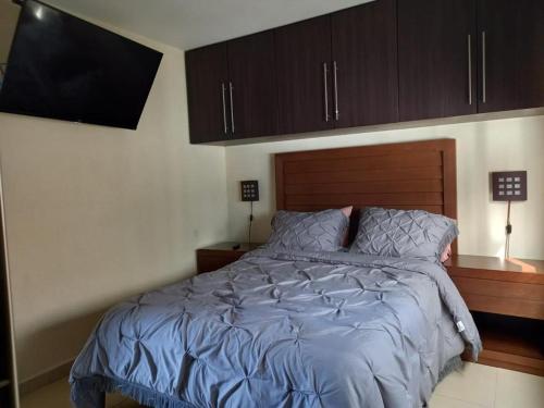 1 dormitorio con 1 cama con cabecero de madera en Portal Polanco, en Ciudad de México