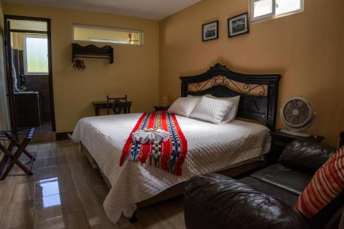 a bedroom with a bed and a couch at El Delfin Hotel y Restaurante in San Pedro La Laguna