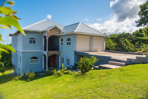 a house on top of a grassy hill at RunAway to Tranquility, overlooking the Bay in Runaway Bay