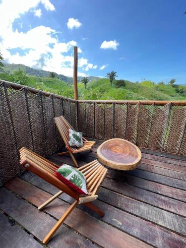 a wooden deck with a table and two chairs and a table at The Valley Tayrona hostel- A social jungle hostel in El Zaino