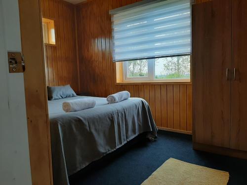 a bedroom with a bed with towels on it at Cabañas Quimantu-Aguas Calientes in Puerto Varas
