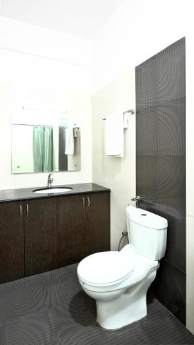 a bathroom with a white toilet and a sink at Franria Villa Guest House in Calangute