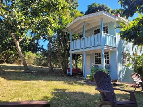 a white house with two chairs in the yard at Herbert's Place in Cabo Rojo