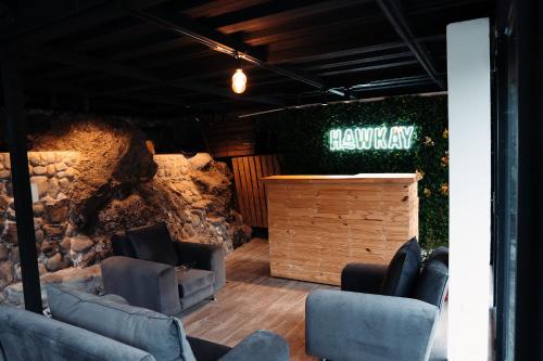 a lobby with chairs and a stone wall at Hawkay Glamping in San Miguel de Salcedo