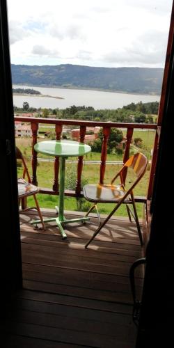 a table and chairs on a porch with a view at Mirador Valeisa in Guatavita