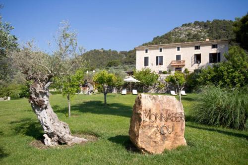 a rock with the word kindness written on it next to a tree at Monnaber Nou Finca Hotel & Spa in Campanet