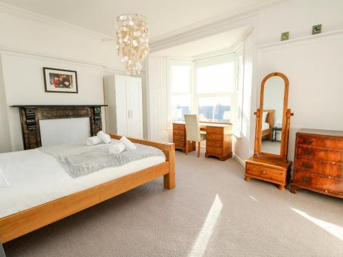 a bedroom with a bed and a desk and a mirror at Chesil Views in Portland