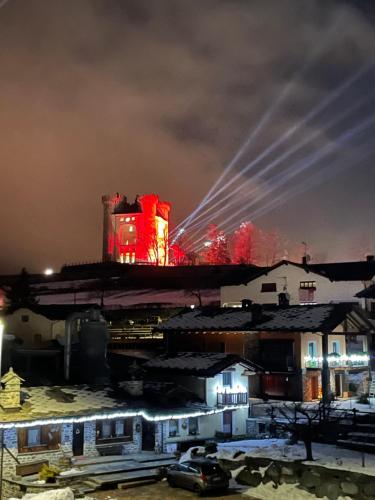 a building with red lights in a city at night at Maison Élie in Aymavilles