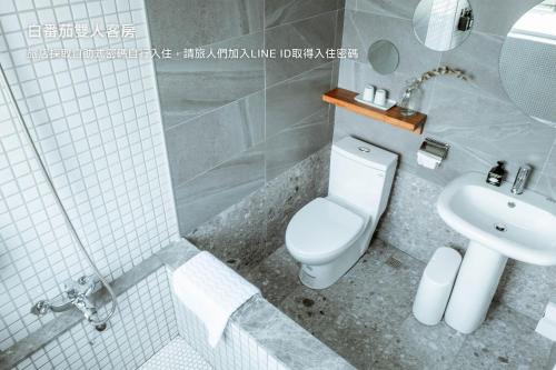 a bathroom with a toilet and a sink at Hostel Tomato 番茄溫泉青旅 in Jiaoxi