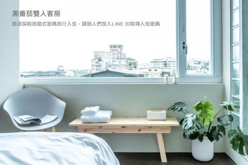 a bedroom with a desk and a window at Hostel Tomato 番茄溫泉青旅 in Jiaoxi